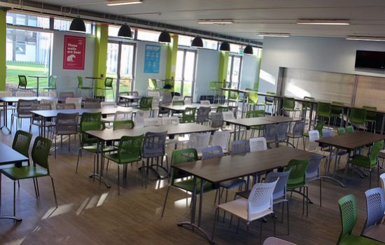 A canteen filled with lots of desks and chairs