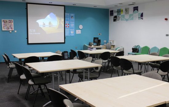 A classroom filled with lots of tables and chairs