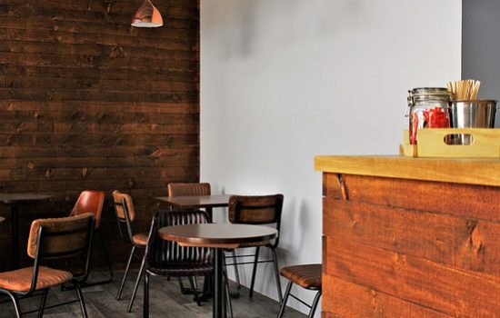 A restaurant with wooden walls and chairs and a counter